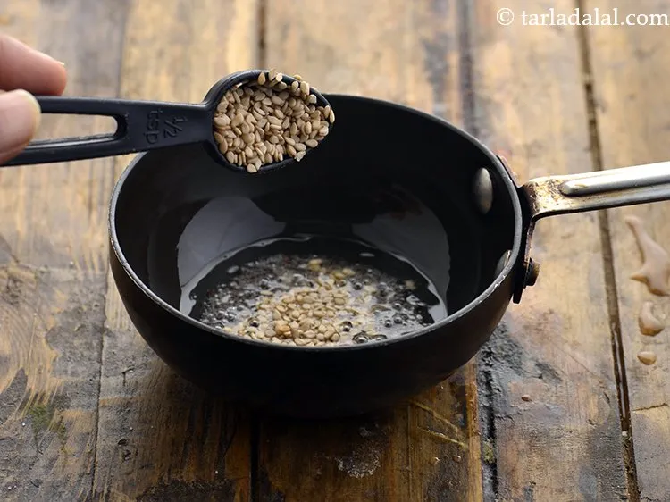 Step 23 – When the seeds crackle, add the sesame seeds.
