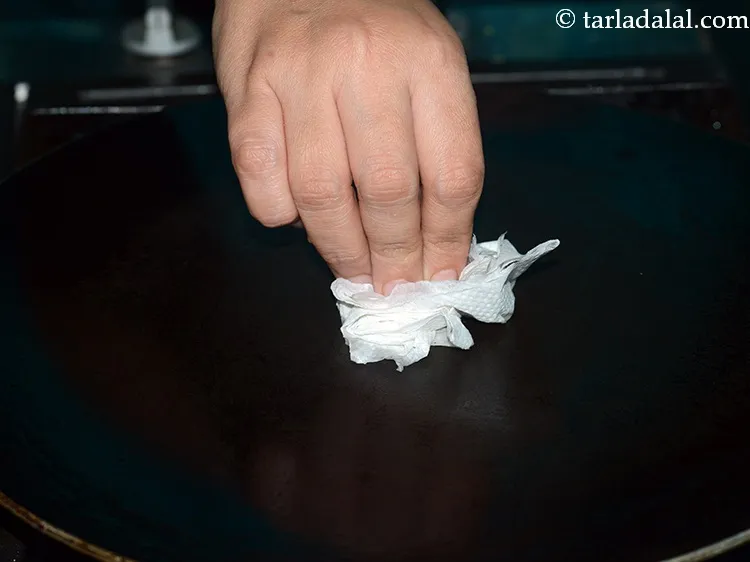 Step 25 – To prepare <strong>instant oats dosa</strong>, heat a non-stick tava (griddle) and grease it using &frac14; …