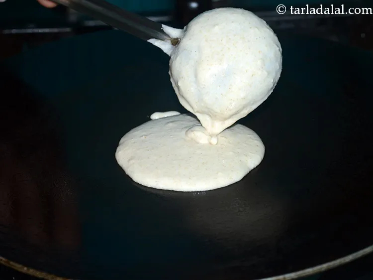 Step 26 – Pour a spoonful of the batter on the tava (griddle).