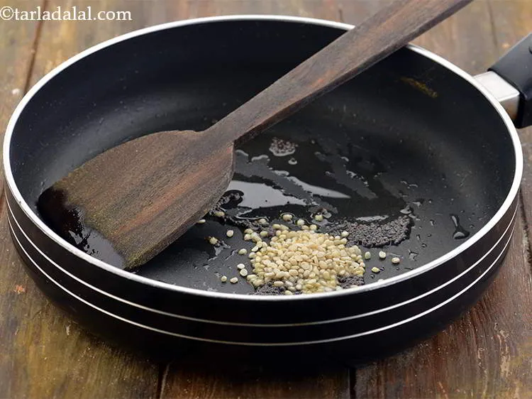 Step 9 – When the seeds crackle, add the urad dal. You can also add chana dal.