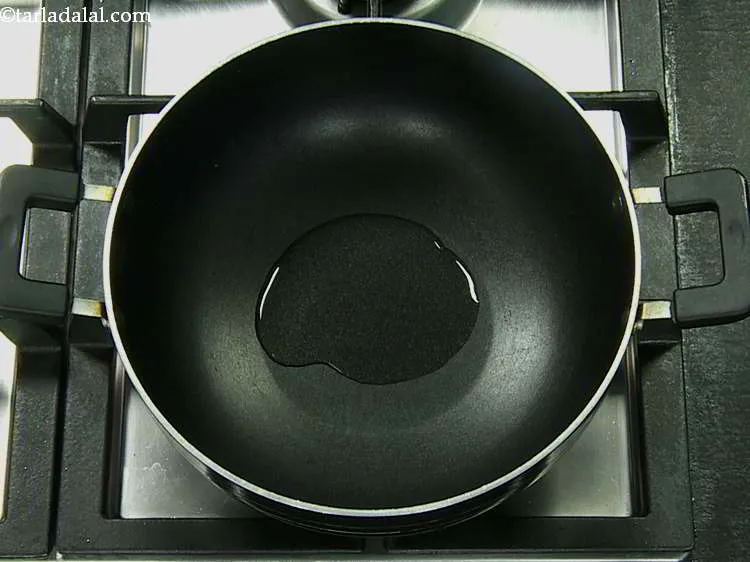 Step 8 – For making the <strong>onion and karela sabji</strong>, heat the oil in a deep non-stick kadhai.