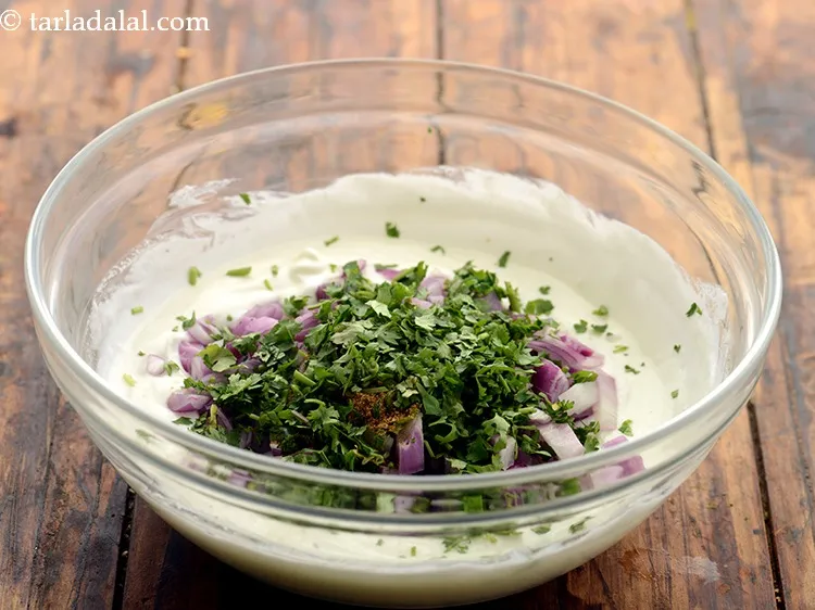 Step 12 – Add coriander. It will give add freshness to the <strong>onion raita</strong>.&nbsp;