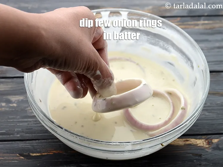 Step 21 – Dip the onion rings one by one in the batter till they are evenly coated …