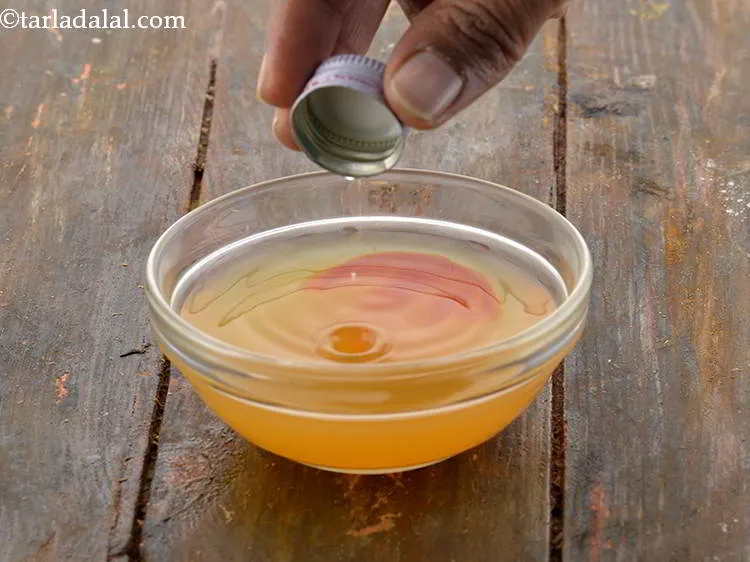 Step 5 – Also, add the orange essence to flavour the <strong>Orange Glaze Icing.&nbsp;</strong>Keep aside.
