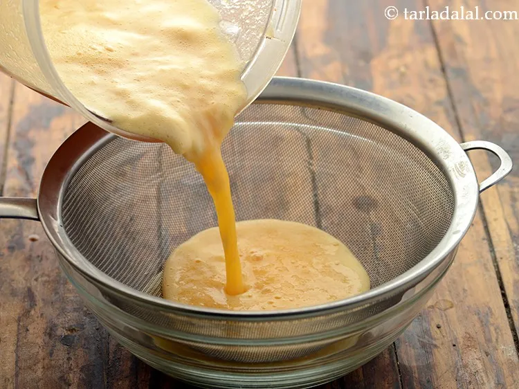 Step 20 – Transfer the <strong>homemade orange juice</strong> into a strainer. Prefer using a strainer with slightly bigger …