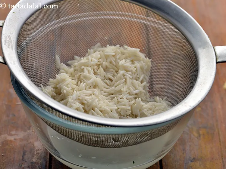 स्टेप 2 – एक छलनी का उपयोग करके चावल को पूरी तरह से …