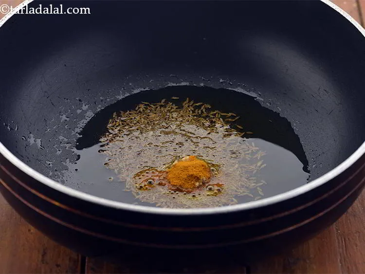 Step 17 – When the seeds crackle, add the asafoetida and turmeric powder.