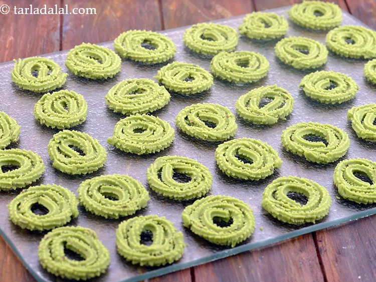 Step 21 – Press out 50 mm. (2&rdquo;) diameter round swirls of chakli onto an inverted flat thali, …