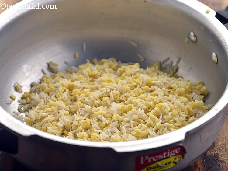 Step 11 – To prepare the&nbsp;<strong>palak khichdi | palak dal&nbsp;khichdi |</strong>, in a pressure cooker, add the soaked …