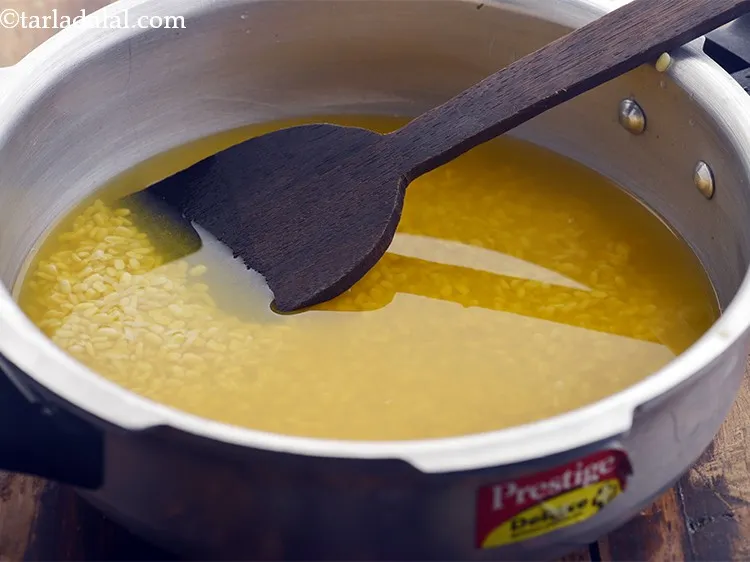 Step 14 – Mix well and pressure cook for 3 whistles or until the rice &amp; dal are …