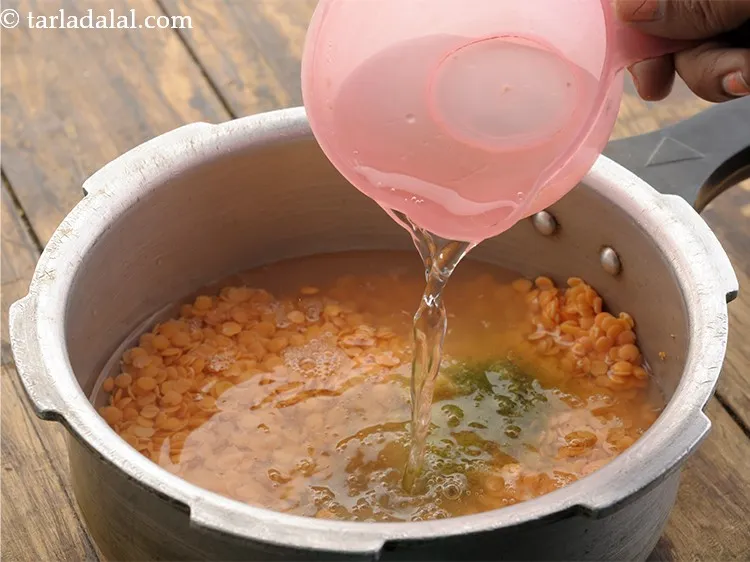 Step 9 – Add 2 cups of water in the pressure cooker and mix well.