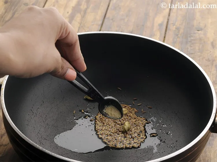 Step 13 – When the seeds crackle, add asafetida.