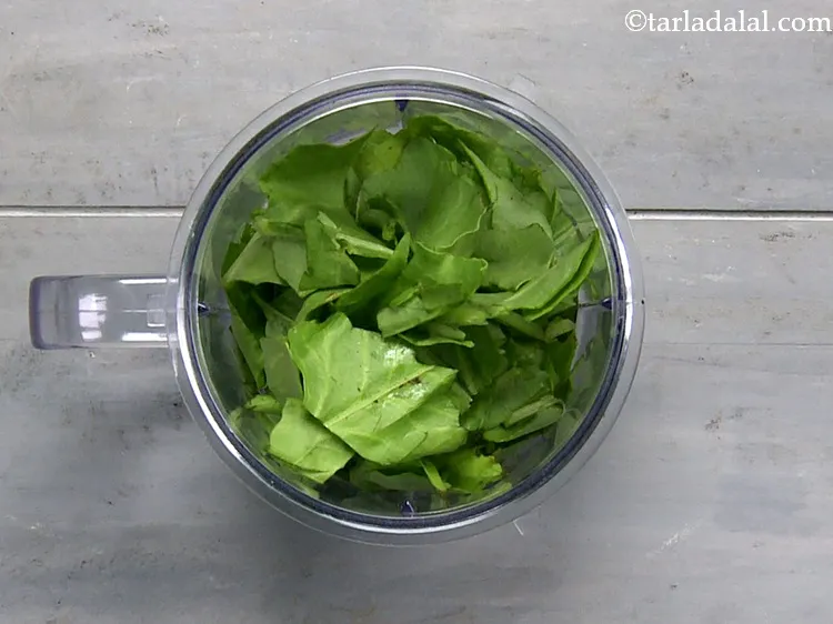 Step 7 – To make the smooth paste, in a mixer jar, take the spinach leaves.