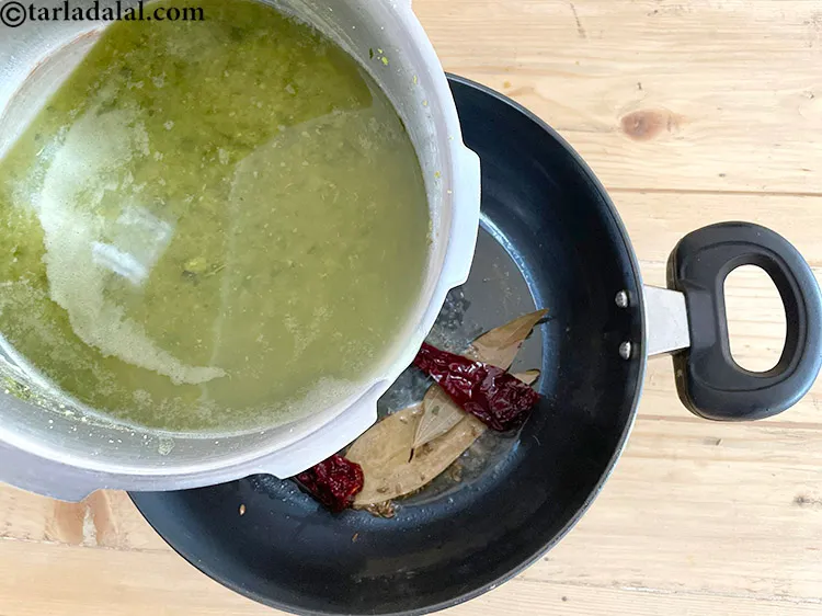 Step 26 – When the seeds crackle, pour&nbsp;the cooked dal over the tempering.
