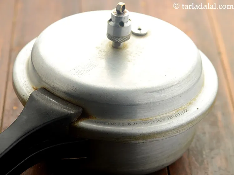 Step 13 – Close the lid of the pressure cooker and allow them to cook for 4 whistles.&nbsp;