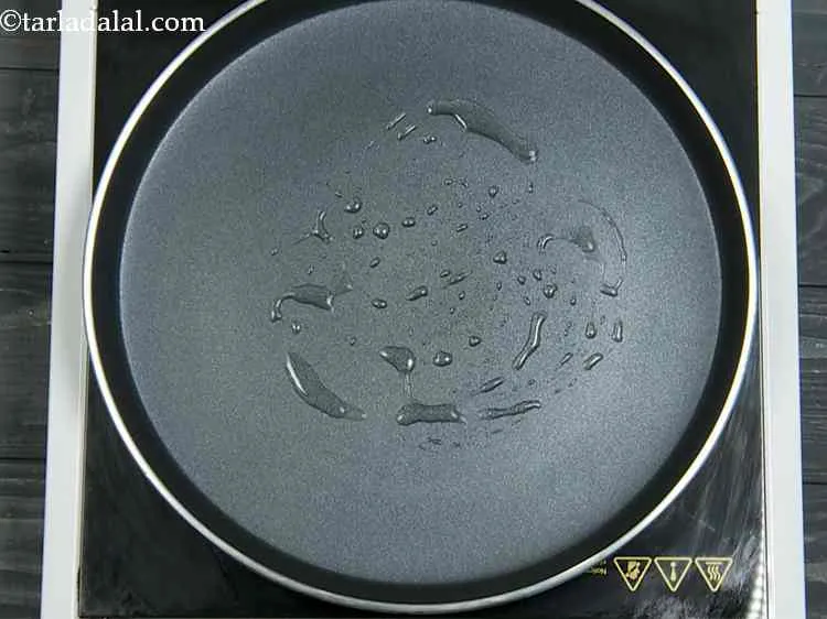 Step 10 – To make paneer cheese toast, heat a non-stick tava (griddle), grease it using 1 tsp …