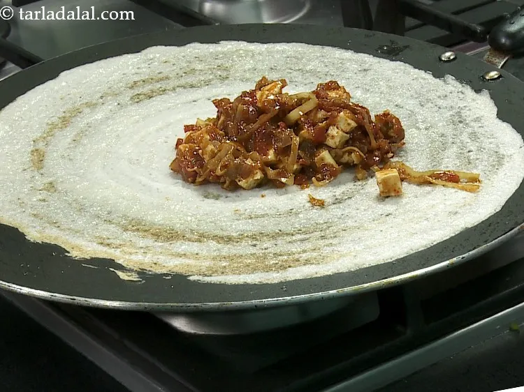 Step 32 – Spread 1 portion of the paneer chilly stuffing all over the dosa.