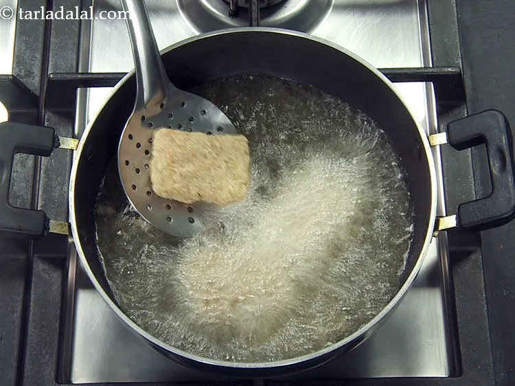 Step 24 – Heat the oil in a deep non-stick pan and add a few marinated paneer cubes …