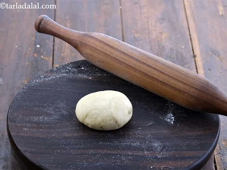Step 16 – Dip one portion of the dough in flour and flatten it lightly on the rolling …