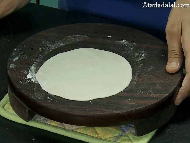 स्टेप 10 – थोड़े से मैदा का प्रयोग करके आटे को 100 मिमी. …