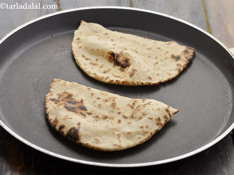Step 39 – Just before serving, warm pita bread halves on a non-stick tava (griddle).