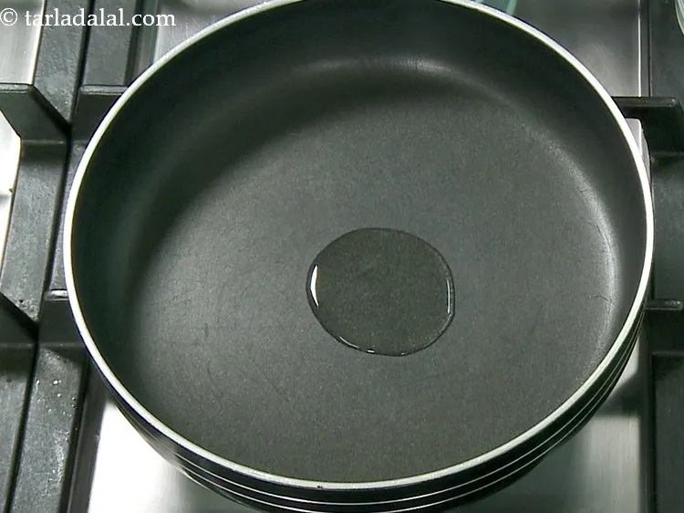 Step 1 – To make <strong>paneer stuffing for paneer schezwan</strong>, heat the oil in a broad non-stick pan.