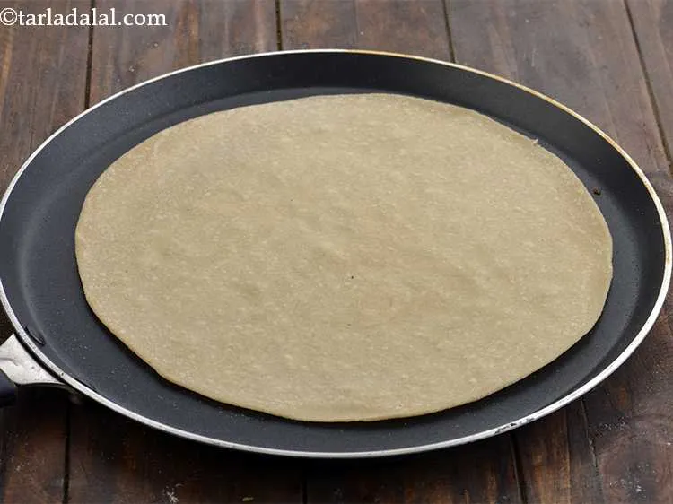 Step 16 – To assemble <strong>cottage cheese schezuan frankie</strong>, heat a non-stick tava (griddle) and place a flour …