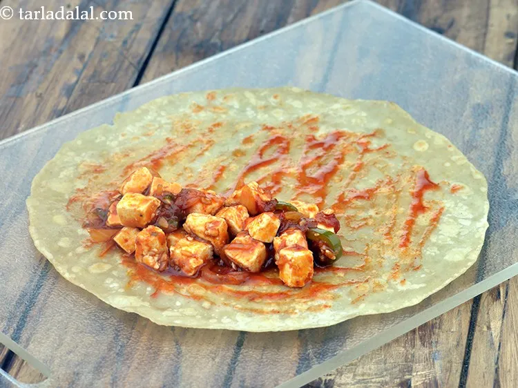 Step 21 – Put one portion of the prepared paneer stuffing on one side.