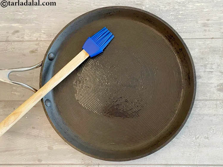 Step 33 – <meta charset="UTF-8" /> Heat a non-stick tava (griddle) and grease with oil using a brush.