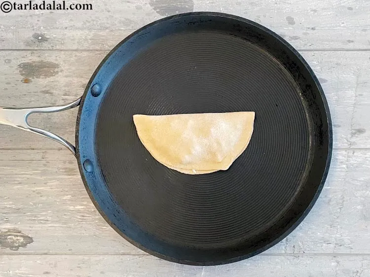 Step 27 – Place the roti on the pan and cook the bottom side.