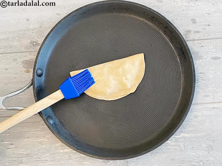 Step 28 – Grease the top of the uncooked paratha with a little oil using a brush.
