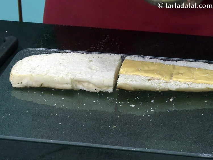 स्टेप 21 – ब्रेड के ऊपरी आधे भाग पर दो चीज़ स्लाइस रखें।