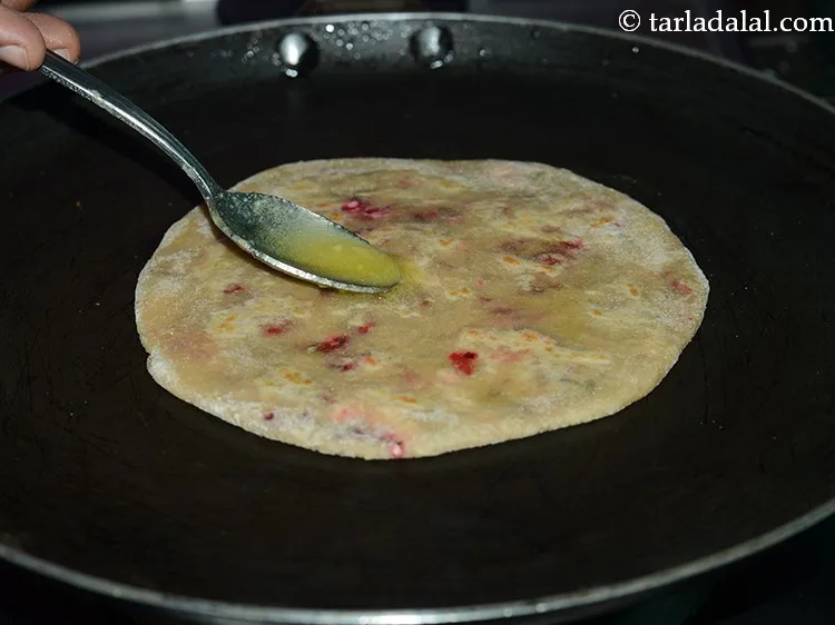 Step 21 – Cook the paratha, on a medium flame using &frac12; tsp of ghee.