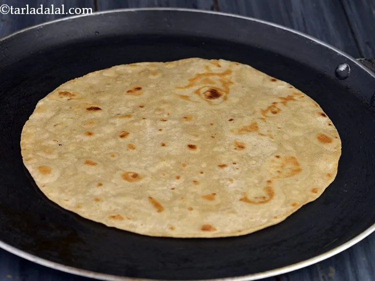 Step 26 – Add &frac14; tsp of peanut oil and lightly cook the over chapattis on a tava, …