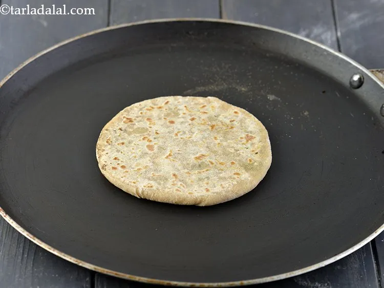 स्टेप 28 – <strong>पापड़ स्टफ्ड पराठे</strong> को गरम तवा पर धीरे से रखें। …