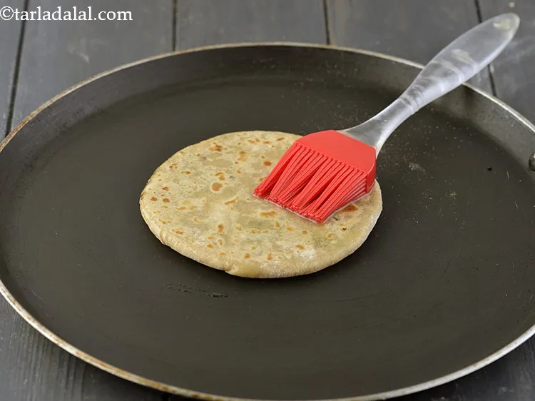 स्टेप 29 – पराठे को पलटें और १ टीस्पून मूंगफली के तेल का …