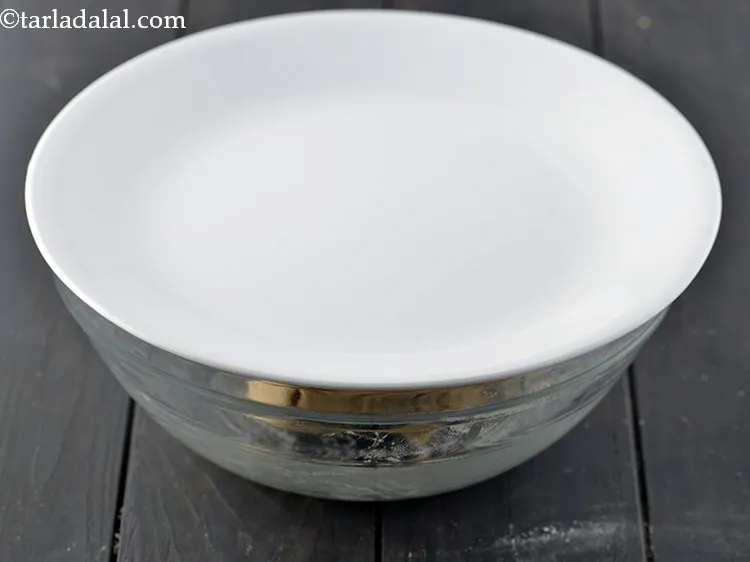 स्टेप 6 – आटे को मलमल के कपड़े या प्लेट से ढककर १५ …