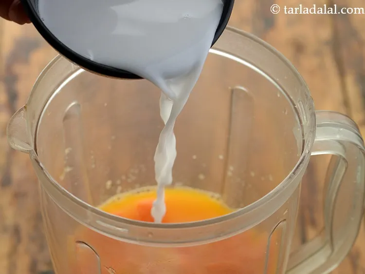 Step 10 – Finally add coconut milk to make orange papaya coconut drink.
