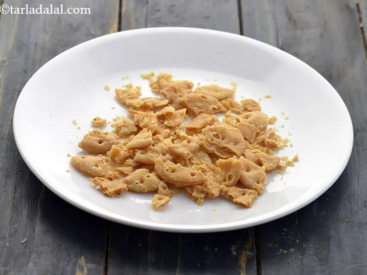 Step 13 – For making the <strong>papri chaat</strong>, take 7 papdis and coarsely crush them.