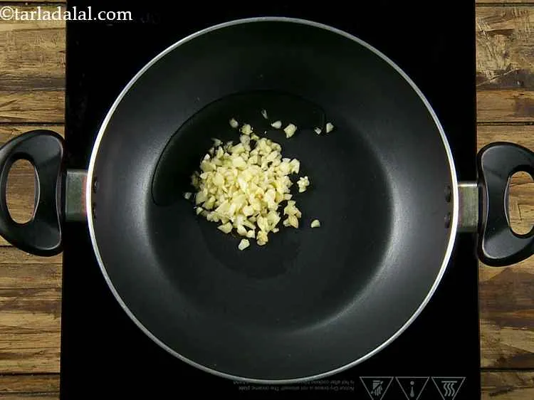 Step 2 – Once the oil heats up, add the garlic. It will start to sizzle.