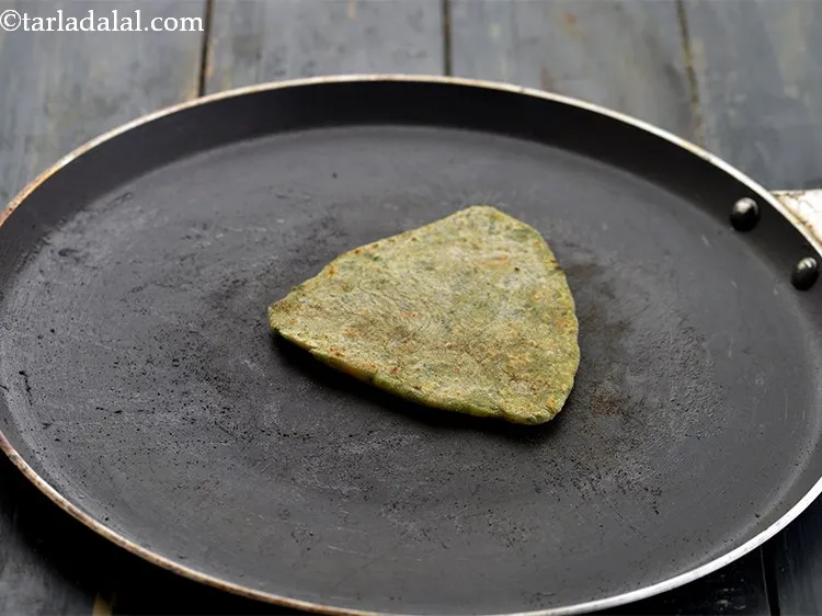 Step 22 – Heat a non-stick tava (griddle) and place the <strong>paushtic paratha</strong> over it. Cook till small …