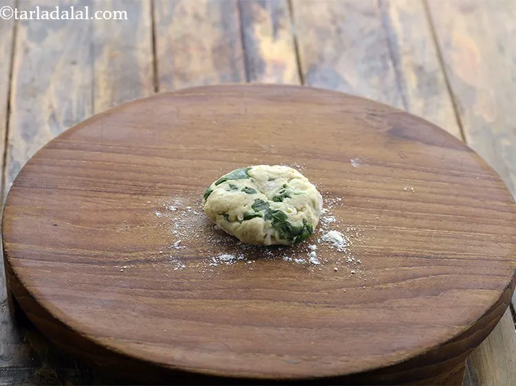 Step 14 – Place a portion of dough ball on rolling board and press it.