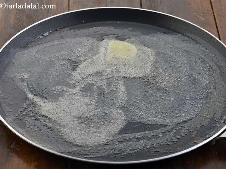 Step 24 – Heat a large tava, add 2 tsp of butter.