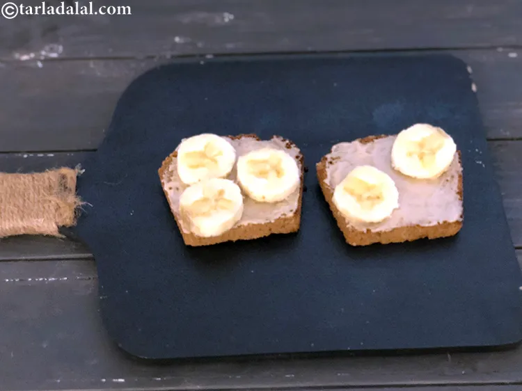 Step 4 – Top each&nbsp;<strong>toasted buttered multigrain bread slice</strong>&nbsp;with half the bananas.