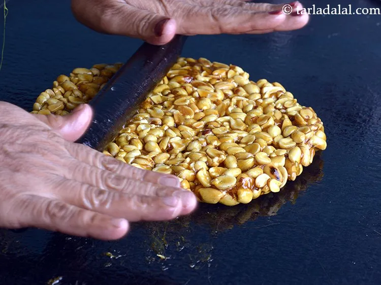 Step 13 – Roll the <strong>moongfali chikki </strong>using a greased rolling pin to make 275 mm. (11&rdquo;) diameter …