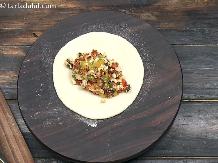 स्टेप 15 – गोल के बीच में स्टफिंग का एक भाग रखें।