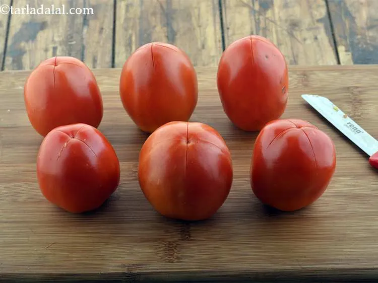 Step 2 – Make a criss-cross on the base of each tomato using a sharp knife. Make sure …