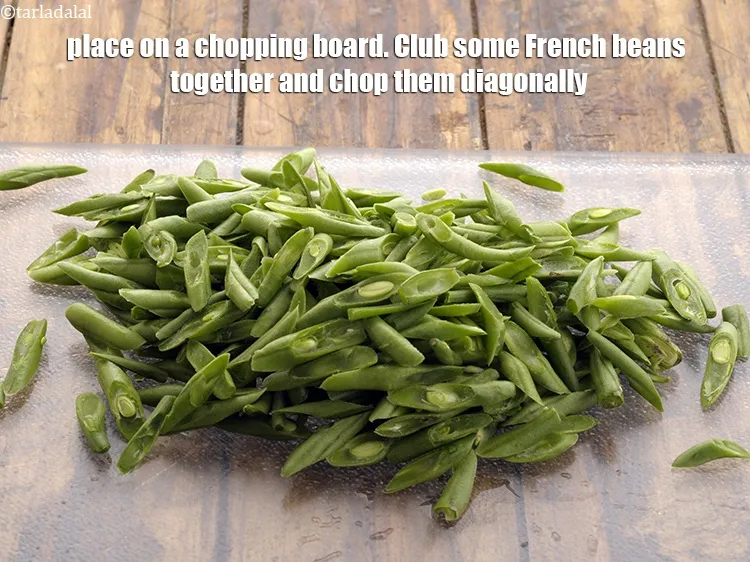 Step 5 – Place on a chopping board. Club some French beans together and chop them diagonally.<br /> …