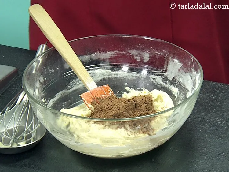 Step 20 – To give nice rich brown colour to <strong>Christmas eggless plum cake</strong>, add cocoa powder.&nbsp;