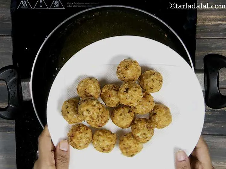 स्टेप 13 – <strong>पोहा पकोड़ो</strong> को तेल सोखनेवाले कागज पर निकाल लें।